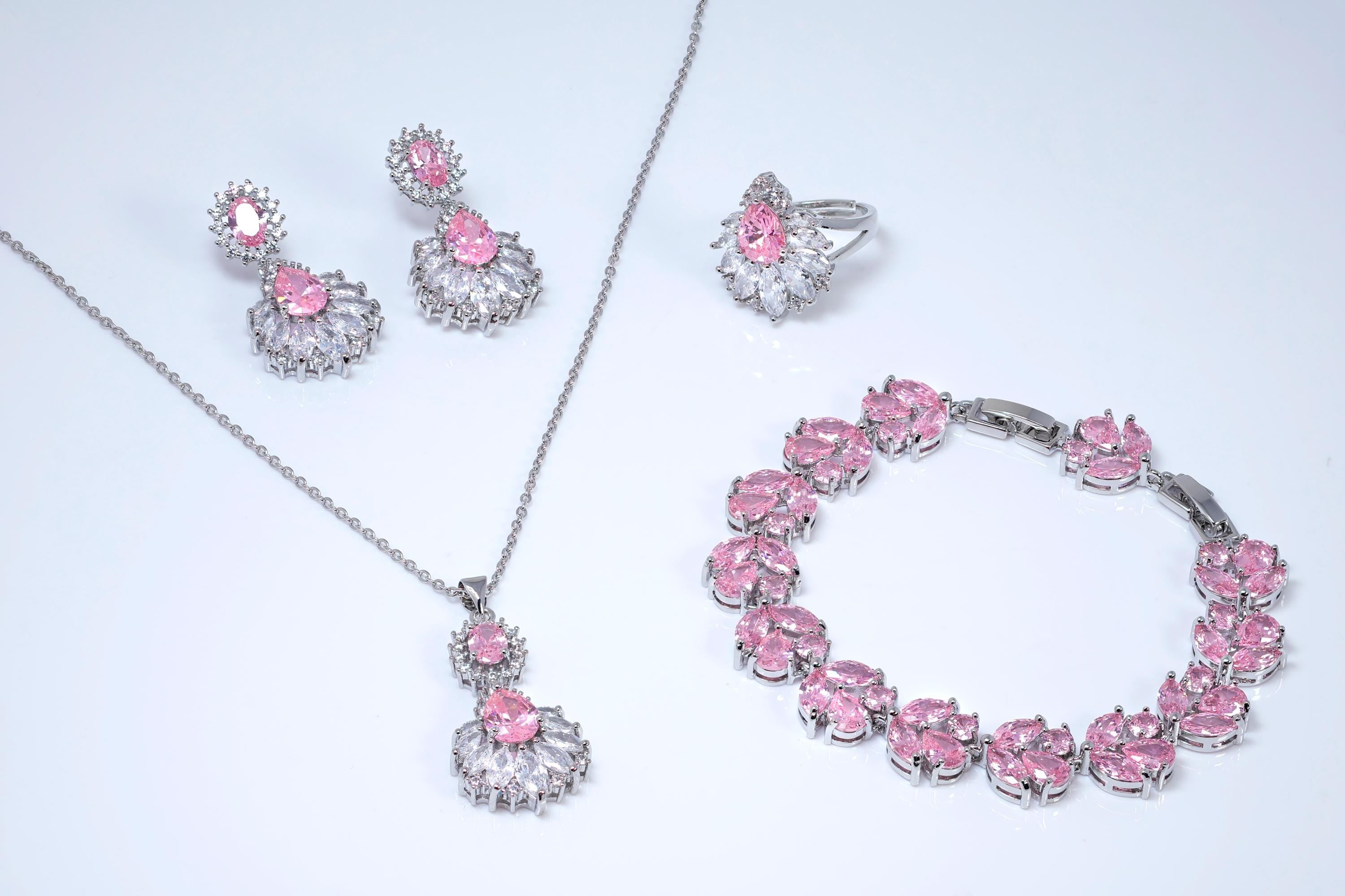 a collection of jewelry pieces, including earrings, a necklace, a ring, and a bracelet, all featuring pink gemstones.