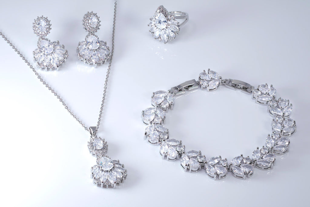 a collection of elegant jewelry pieces, including a necklace, earrings, a ring, and a bracelet, all adorned with sparkling crystal stones.
