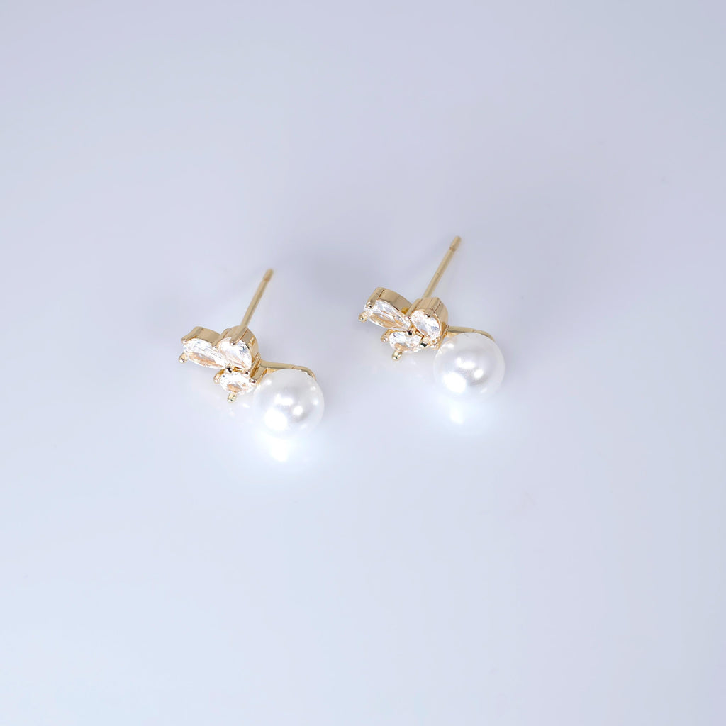 A pair of gold earrings with white pearls and small gemstones.