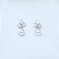 A pair of elegant earrings with a pearl and a crystal embellishment.