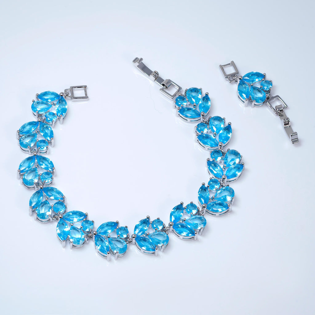 A silver necklace with blue gemstone pendants is displayed on a white background.