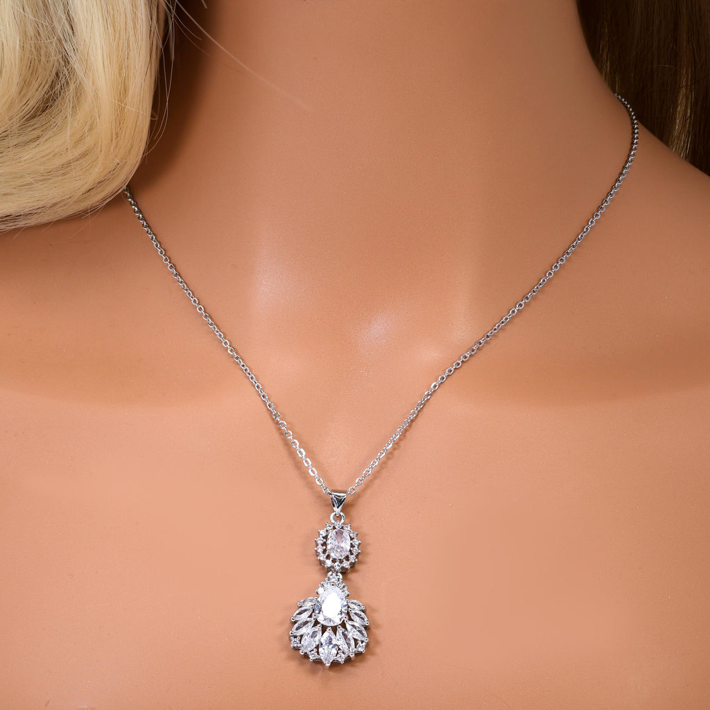 A close-up view of a delicate necklace with a pendant featuring a floral design.