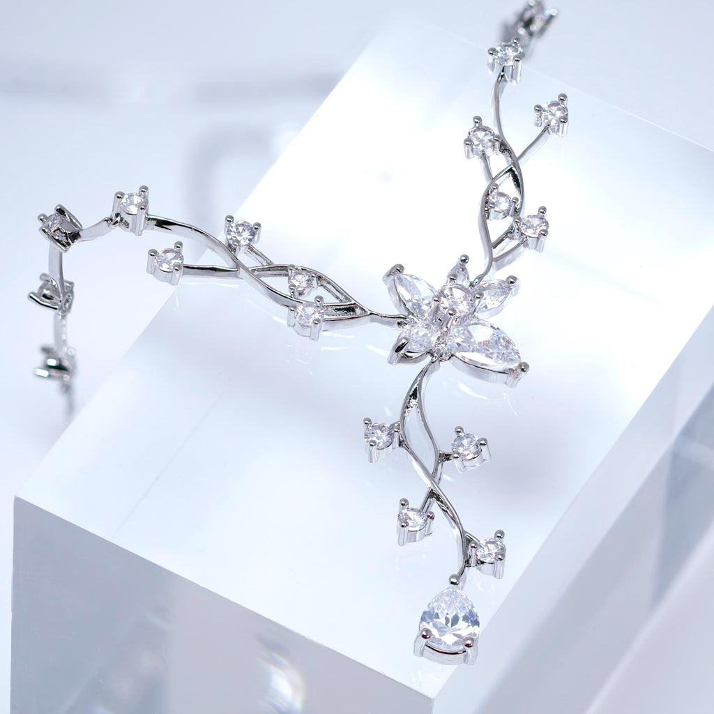 A close-up view of a delicate, sparkling necklace with a large, intricate flower-shaped pendant.